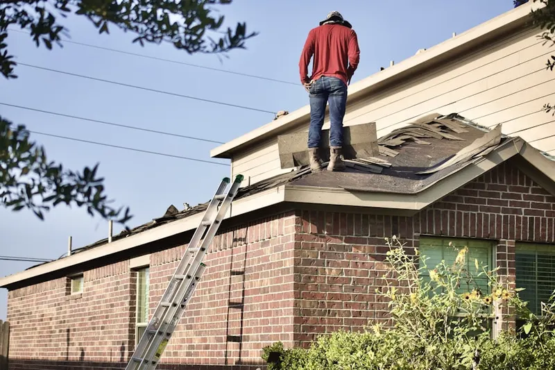 Professional roofer working on a residential roof in Saint Vrains